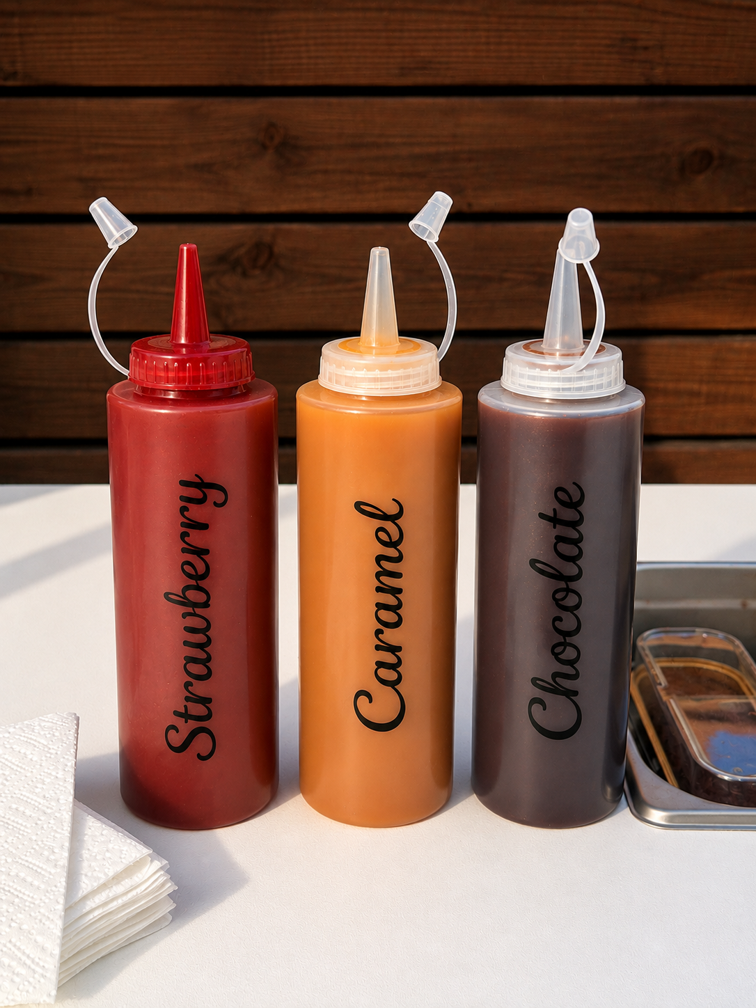 Strawberry, caramel and chocolate sauces for the cake bar