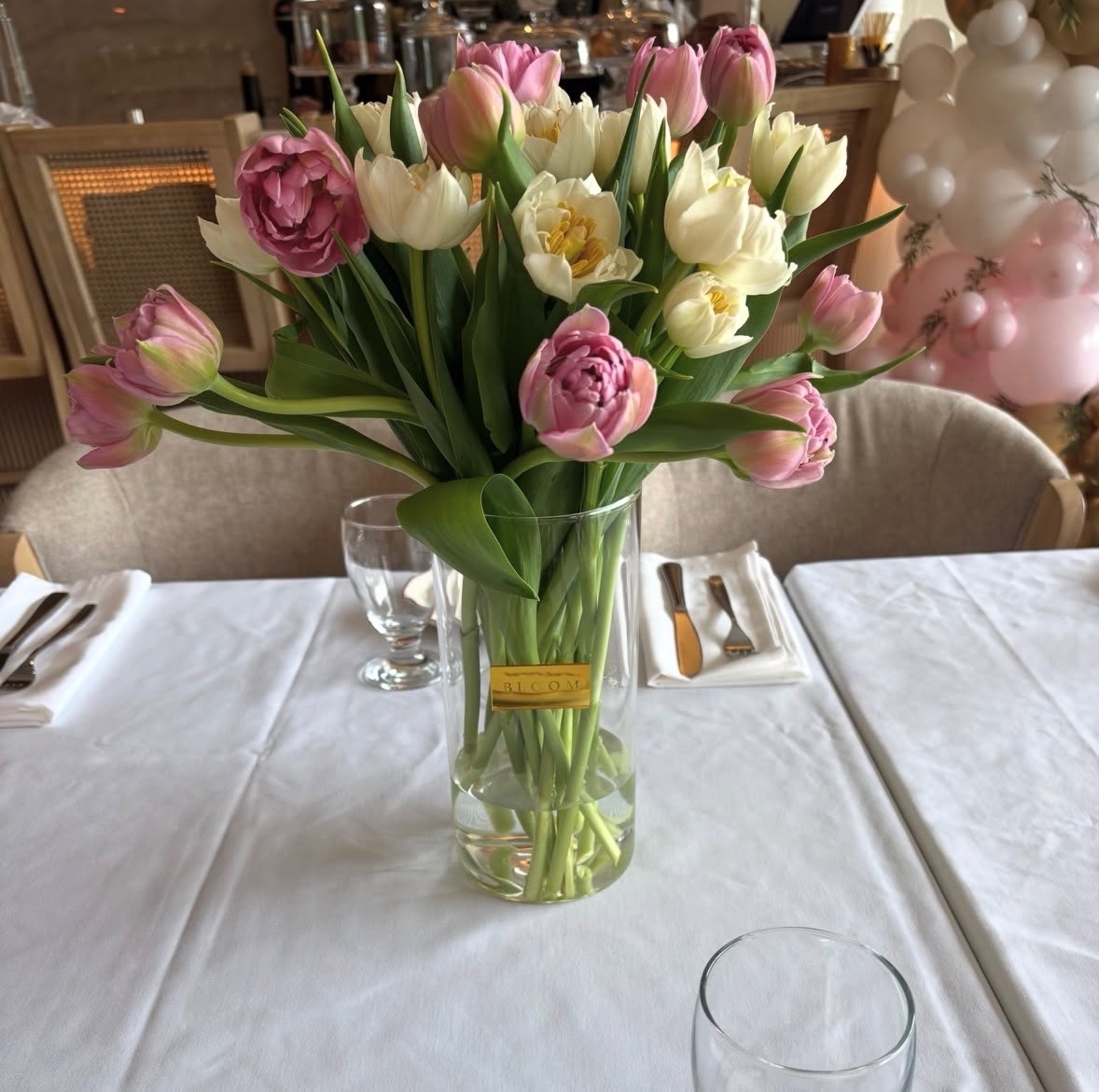 Pink and ivory tulip centerpiece in glass vase